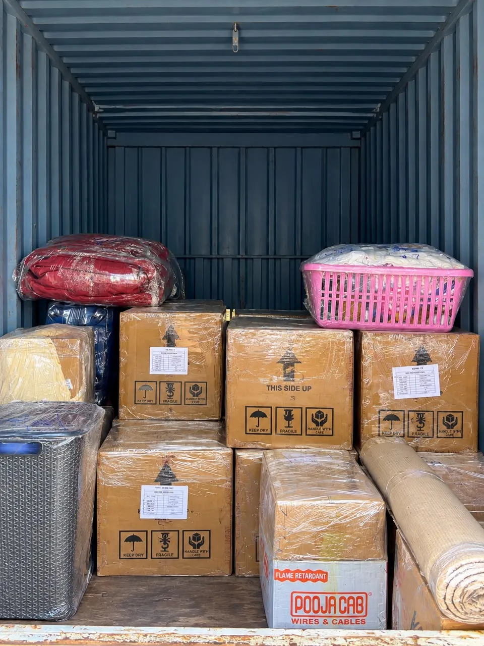 Neatly stacked cartons with fragile and this-side-up labels inside a shipping container